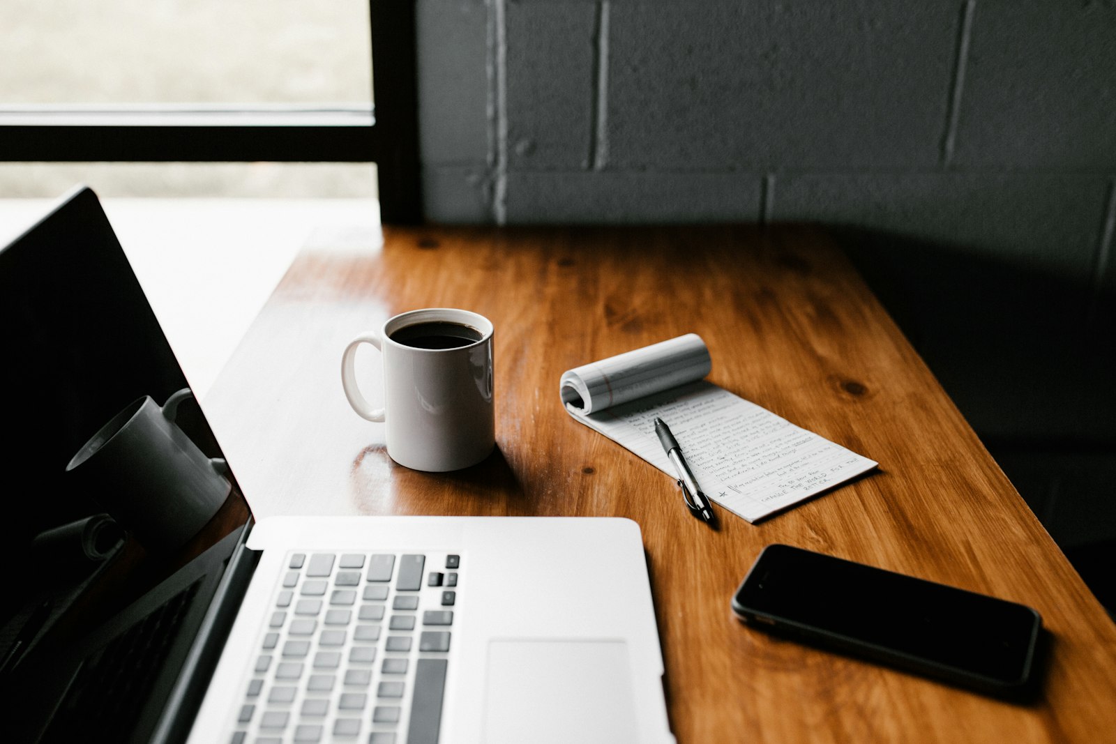A tidy desk with a laptop, coffee and a notebook ready for a focused morning